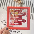 Close-up of five red New Year hair clips with folk deity motifs on a display stand - God of Wealth Gift Set