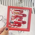 Detail view of five red cartoon hair clips with Fu character in a red display gift box - Five Blessings Doll Gift Set