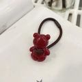 Close-up of a glossy red bear charm on a dark brown elastic hair tie for kids - Round Red Bear Hair Tie / Red