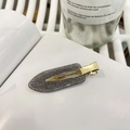 Detail einer grauen Glitzer-Haarspange mit goldener Metall-Entenschnabel-Klammer - Graukaffee