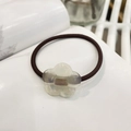 Detail of high-elastic hair tie featuring a pearlescent white flower with France Handmade text - Pearlescent Mermaid Color