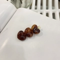 Tre fermagli per capelli a forma di cuore in resina ambra su una pagina di libro - Stile Triplo Cuore Ambra