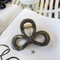 Detailed view of the dark grey bow-shaped hair claw clip with golden metal spring - Dark Gray