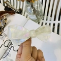 Detalle macro del pasador de lazo en acetato blanco crema con letras de France Handmade - Sirena Blanca