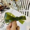Vista detallada de la pinza de acetato verde oliva con texto dorado a mano - Verde Gelatina