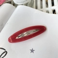 Close-up of a bright red oval acetate hair clip with gold Barrette La France lettering - Rose Red Jelly