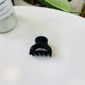Détail d'une pince à cheveux demi-cercle noir mat avec 5-6 dents sur surface blanche - Serrure Creuse Boucle Papillon / 4cm / Noir mat