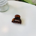 Vue détaillée d'une pince à cheveux en résine ambre écaillée sur une table blanche - Serrure Creuse Boucle Papillon / 4cm / Marron Rouge Mat