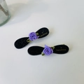 Detail of black glitter hair clips featuring purple ribbon roses and gold lettering - Elegant Noble Purple Rose