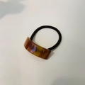 Dettaglio dell'elastico per capelli in resina ambra fatto a mano con incisione - Elastico Curvo / Ambra
