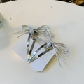 Vue détaillée de deux barrettes nœuds argentées avec perles blanches et strass - Perle Argent Brillante Double Nœud-Pince à Clip