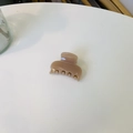 Nahaufnahme einer kleinen quadratischen rosa Haarklammer aus glänzendem Harz für das Styling - Dunkles Nude-Rosa