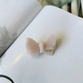 Pink and white marble acetate butterfly hair clip with gold logo on a minimalist book - Water Pink