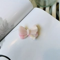 Dettaglio del fermaglio per capelli a fiocco in acetato marmorizzato rosa con logo oro - Rosa bicolore