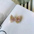 Dettaglio del fermaglio a farfalla in acetato con trama marmorizzata rosa e gialla - Floreale Viola