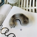 Dettaglio della clip per capelli con motivo a inchiostro e lettera in metallo su marmo - Stile Arco Grigio Gelatina (Circa 8cm)