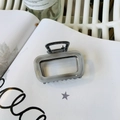 Dettaglio ravvicinato di una pinza per capelli rettangolare grigio marmo su una rivista - Stile Rettangolo Grigio Gelatina (Circa 6.5cm)