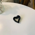 Gros plan d'une pince à cheveux noire brillante en forme de cœur sur fond blanc - Mini boucle papillon coeur creux / Env. 4cm / Noir Brillant