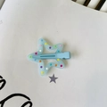 Dettaglio di una molletta a stella azzurra con pois colorati su una superficie bianca - Stella Pois - Blu / Blu