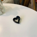 Vue de dessus d'une pince à cheveux mate noire en forme de cœur creux sur fond blanc - Mini boucle papillon coeur creux / Env. 4cm / Noir mat