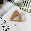 Detail of a nude triangular shark hair clip on a book with soft natural lighting - Approx 6cm / Deep Nude Pink