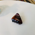 Gros plan détaillé d'une petite pince à cheveux triangulaire ambre avec dents noires - Brun Rouge Brillant (Env. 4.3cm)