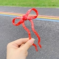 Vista dettagliata del fermaglio per capelli in acetato rosso marmorizzato con fiocco a onde - Rosso (Circa 15cm)