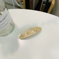 Détail de la pince à cheveux en acétate crème avec étoiles dorées et strass multicolores - Barrette Ressort Lune Étoile Beige Pailletée