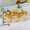 Macro shot of three connected yellow and cream mushroom acetate hair claws on a stand - 8.7cm / Yellow Pink Mushroom Head Bowknot
