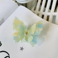 Detailed macro view of pearlescent dual-layer butterfly hair claw with gold spring - Gradient Blue Green