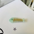 Detail view of a mint green fishbone hair clip with gold accents on a white background - Fish Bone Duckbill Clip