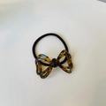Dettaglio dell'elastico per capelli con fiocco a strati e trama a tartaruga blu - Doppio Fiocco Floreale Marrone