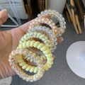 Close-up of assorted spiral telephone cord hair ties in various colors and patterns - Yellow Strawberry Cheese Style