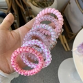 Detail of pink spiral telephone wire hair ties with various patterns and high elasticity - Barbie Pink Style