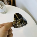 Detalle macro del patrón de carey en la pinza para el cabello de acrílico pulido - Café con Leche