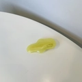 Macro view of wave-shaped yellow resin hair clip with gold SANSHINE Handmade logo - Transparent Yellow