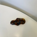 Detailed macro view of the handmade wave-shaped amber tortoiseshell hair clip detail - Blue Floral Tortoiseshell