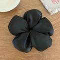 Gros plan détaillé d'un grand chouchou fleur en tissu noir sur une table en bois - Noir