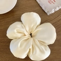 Détail macro d'un chouchou floral en satin crème sur un fond en bois sombre élégant - Blanc Cassé