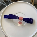 Dettaglio del fermaglio per capelli a fiocco in acetato blu con ciondolo a perla rosa - Blu scuro