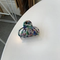 Close-up of marble pattern acetate hair claw clip with colorful artistic texture details - Blue Green Pink Floral