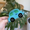 Vue rapprochée d'une pince à cheveux bleue en acétate en forme d'excavatrice - Voiture Bleue