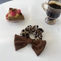 Chouchou élégant à imprimé léopard avec nœud marron dans un décor de thé raffiné - Imprimé léopard