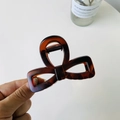 Macro shot of a dark tortoiseshell bow hair claw clip with a glossy acetate finish - Matte Red Brown - Bow Buckle Square Bow