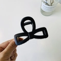 Detail shot of a matte black bow-shaped claw clip with a strong metal spring mechanism - Matte Black - Bow Buckle Square Bow