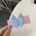 Dettaglio di due fermagli per capelli azzurri a forma di ravanello su carta rosa - Clip a Becco d'Anatra Carota / Blu