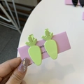 Close-up of two matte green carrot-shaped hair clips on a pink presentation card - Carrot Duckbill Clip / Grass Green