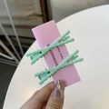 Dettaglio di fermagli per capelli ondulati verde menta su cartoncino rosa per styling - Verde Menta