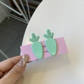 Detail view of two mint green carrot-shaped hair clips on pink cardboard packaging - Carrot Duckbill Clip / Lake Green