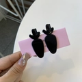 Detail of two black carrot-shaped acetate hair clips on a pink display card - Carrot Duckbill Clip / Black